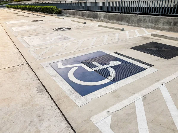 International handicapped (wheelchair) or Disabled parking symbol painted in bright blue on parking space.