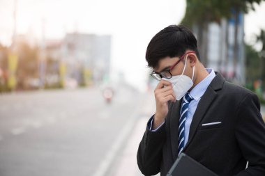 Koruyucu yüz maskesi takan ve öksüren bir iş adamının etrafını sarın. Coronavirus ve 2.5..
