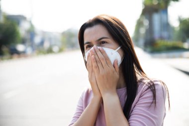 Koruyucu yüz maskesi takan ve öksüren bir kadının etrafını sarın. Coronavirus ve 2.5..