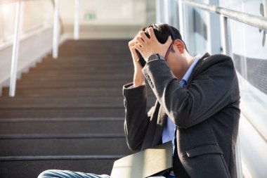 Depresyonda kaybolmuş bir iş adamı yerde oturup duygusal acı çekerken ağlıyor. Stres yapan ve işini kaybeden işsiz insanlar bunalımı. Stresli işsiz kavramı.