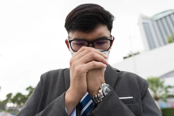 Close up of a businessman in a suit wearing Protective face mask and cough, get ready for Coronavirus and pm 2.5 fighting against in city background.