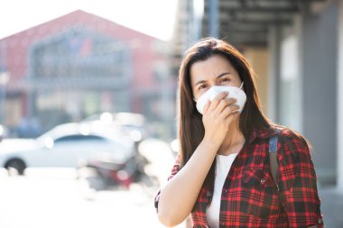 Koruyucu yüz maskesi takan ve öksüren bir kadının etrafını sarın. Coronavirus ve 2.5..