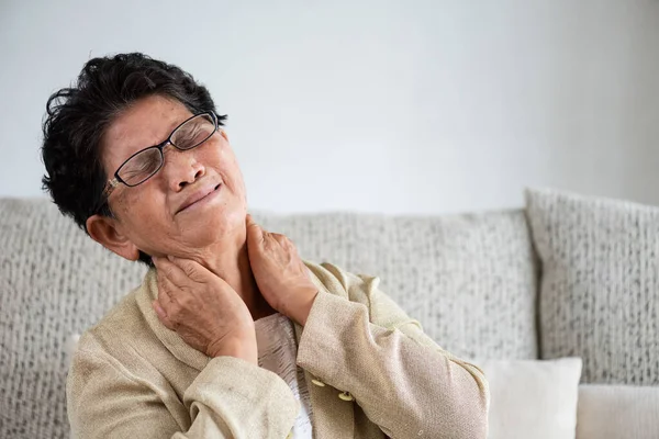アジアの老婦人はソファに座って 首の痛み 家で腰痛を抱えていました シニアヘルスケアコンセプト — ストック写真