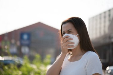 Koruyucu yüz maskesi takan ve öksüren bir kadının etrafını sarın. Coronavirus ve 2.5..