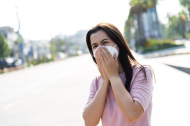 Koruyucu yüz maskesi takan ve öksüren bir kadının etrafını sarın. Coronavirus ve 2.5..