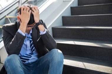 Depresyonda kaybolmuş bir iş adamı yerde oturup duygusal acı çekerken ağlıyor. Stres yapan ve işini kaybeden işsiz insanlar bunalımı. Stresli işsiz kavramı.