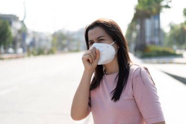 Koruyucu yüz maskesi takan ve öksüren bir kadının etrafını sarın. Coronavirus ve 2.5..