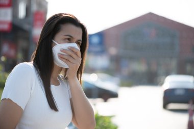 Koruyucu yüz maskesi takan ve öksüren bir kadının etrafını sarın. Coronavirus ve 2.5..