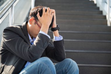 Depresyonda kaybolmuş bir iş adamı yerde oturup duygusal acı çekerken ağlıyor. Stres yapan ve işini kaybeden işsiz insanlar bunalımı. Stresli işsiz kavramı.
