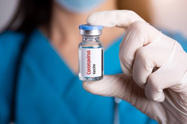 Omzunda steteskop, elinde şırınga ve Coronavirus aşısı olan kadın doktor. Sağlık ve Tıp Konsepti.