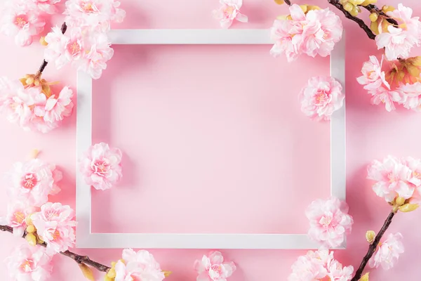 Happy Mother's Day, Women's Day or Valentine's Day greeting concept. Pastel Pink Colours Background with picture frame and blossom flowers flat lay patterns.