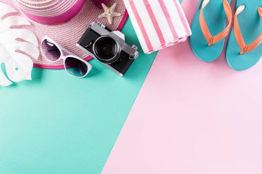 Plaj aksesuarları retro film kamerası, güneş gözlükleri, deniz yıldızı, plaj şapkası ve deniz kabuğu yaz tatili ve tatil konsepti için pastel arka planda..