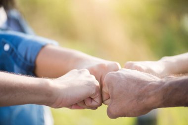 İnsanların birlik ve takım çalışması göstererek yumruk tokuşturduğu alt görüşü kapatın. Arkadaşlık mutluluğu eğlence ortaklık takım konsepti.