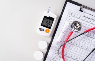 Dünya Diyabet Günü konsepti, Kan Düşürme İnceleme Aletleri, Kırmızı Kalp, kan şekeri takip cihazı, stetoskop ile gri arka plan.