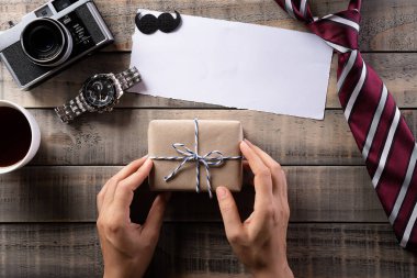 Kahve fincanı, papyon, kravat, gözlük, retro kamera, hediye kutusu ve eski ahşap arka planda bıyıklı Mutlu Babalar Günü konsepsiyonu..