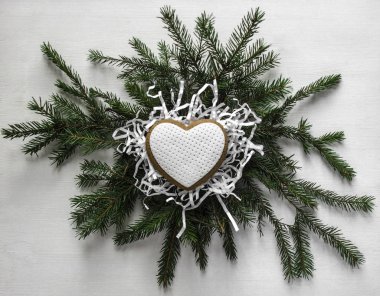 Zencefilli kurabiye beyaz buzlanma ile kalp şeklinde bir kağıt şeker Ladin çelenk üzerinde yatıyor