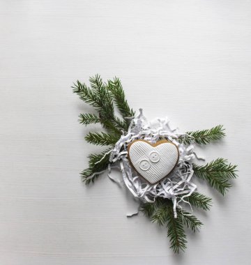 Zencefilli kurabiye beyaz buzlanma ile kalp şeklinde bir kağıt şeker Ladin çelenk üzerinde yatıyor