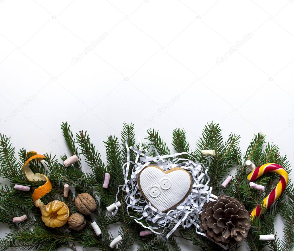 on a white background on the spruce branches lie sweet and tangerine and lump of candy candy and marshmallows