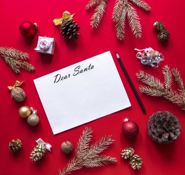 Kırmızı Ahududu arka plan üzerinde yeni yıl ve Noel süslemeleri ve Ladin altın dal bir daire içinde ve merkezi halinde düzenlenmiş yatıyor Noel Baba ve bir kalem bir mektup ile beyaz bir levha