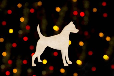siyah bir zemin üzerine sarı ve kırmızı bokeh ışıkların bir arka plan üzerinde bir köpek siluet şeklinde ahşap dekorasyon 