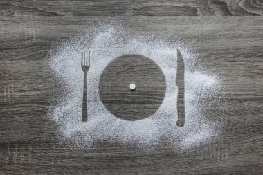 toz toz kar bir siluet ile kaplı ahşap bir zemin üzerine bir tabak çatal bıçak aletleri merkezi olan beyaz yuvarlak tablet 