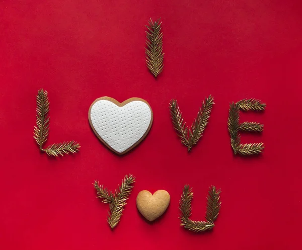 På en röd bakgrund inskriptionen jag älskar dig istället för bokstäver om cookies i form av ett hjärta — Stockfoto