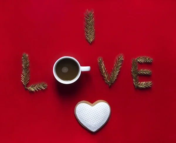 Sobre el fondo rojo la palabra el amor en vez de las letras sobre la taza con el café bajo la galleta en forma del corazón —  Fotos de Stock