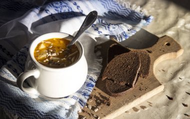 masaya güneşin sarı çorbası ile süsleme desen ve çorba kasesi ile mavi peçete ahşap tahta tohum ekmek 