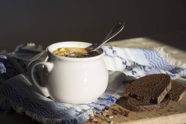 masaya güneşin sarı çorbası ile süsleme desen ve çorba kasesi ile mavi peçete ahşap tahta tohum ekmek 