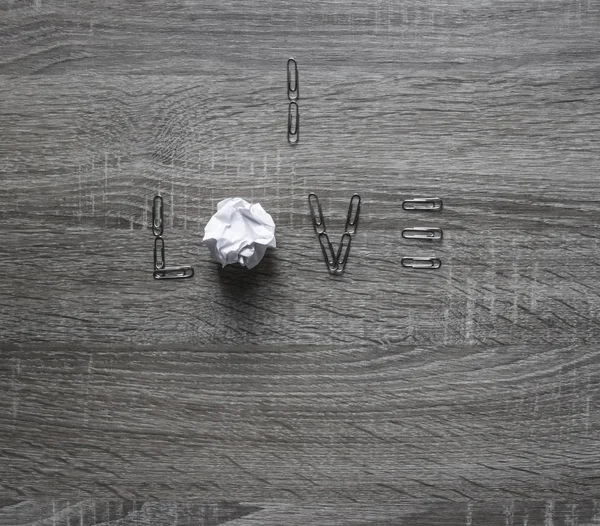 På trä bakgrund är ett klipp av kärlek, i stället för bokstäver o en bit papper mynta — Stockfoto