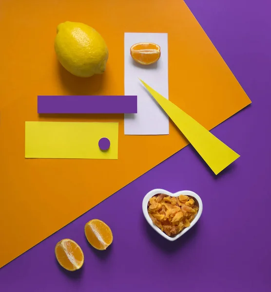 Naranja limón sobre un fondo brillante púrpura amarillo naranja triángulo círculo rectángulo geometría corazón frutos secos frutas confitadas — Foto de Stock