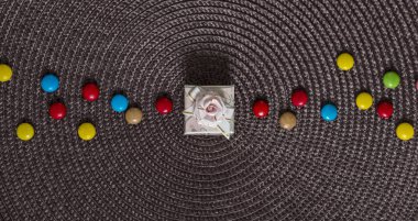 Bir peçeteye Merkezi hediye kutusunda yanındaki şeker renkli bir yay ile 