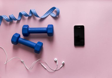 bir pembe arka plan Boks eldiveni mavi renk şerit santimetre telefon smartphone üzerinde kulaklık beyaz 