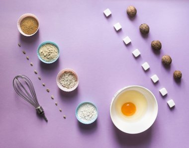 Bir leylak arka plan gıda knolling çapraz ceviz Yunan tohumu ayçiçeği şeker küp rafine Mısır kaşık yumurta yuvarlak kase kek kalıp un mavi pembe