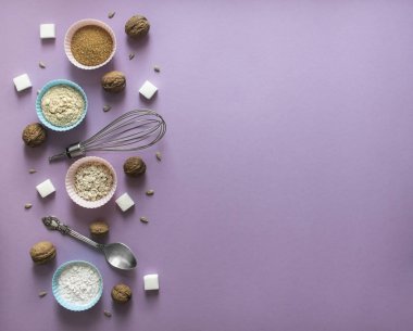 sol düzen kaos karışıklık Fındık ceviz Ayçekirdeği şeker küp rafine Mısır kaşık şekil için kek un mavi pembe bir leylak arka plan üzerinde