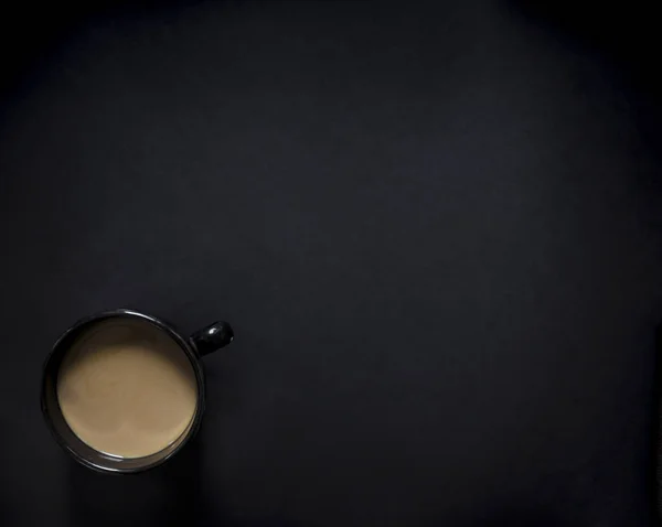 Em uma xícara preta de fundo escuro de preto com vinheta de café e leite horizontal — Fotografia de Stock