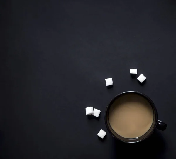 På en svart bakgrund kuber kopp svart kaffe och mjölk socker vinjettering horisontell — Stockfoto