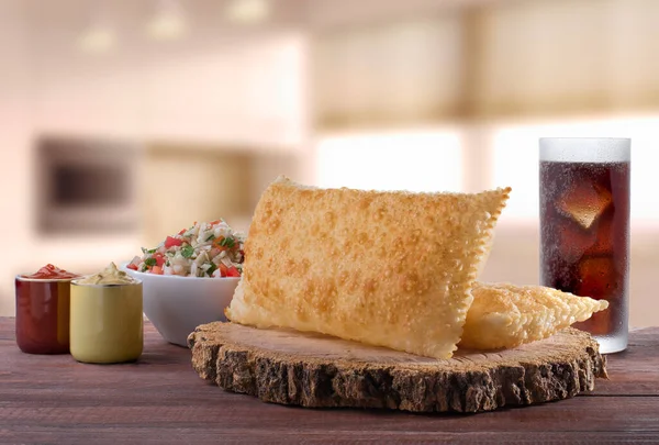 Traditional Brazilian pastry (pastel) with vinaigrette and soda