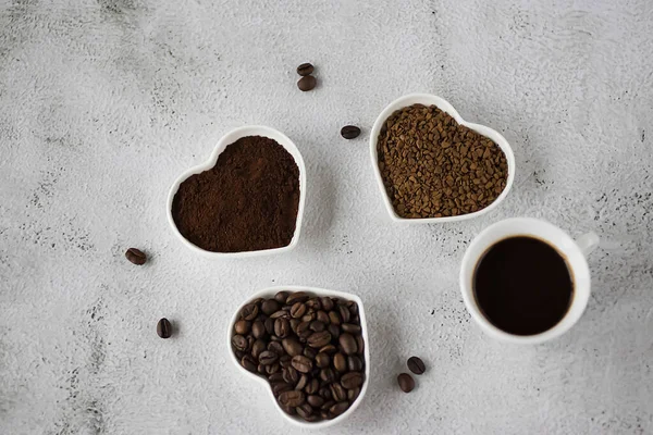 Coffee beans, ground coffee and freeze-dried coffee on light gray background. Soft focus.