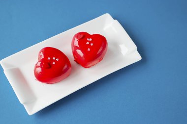 Beyaz tabakta kırmızı kalp kremalı pasta. Sevgililer Günü Konsepti. Yumuşak odak.