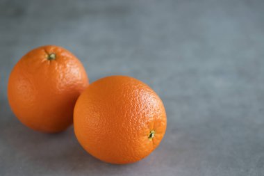 Gri arka planda iki parlak portakal. Yumuşak odaklanma. Boşluğu kopyala