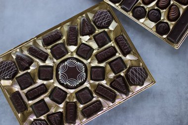 Gri arka planda altın çikolata kutusu. Yumuşak odak.