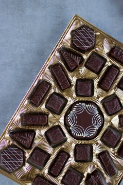 Gri arka planda altın çikolata kutusu. Yumuşak odak.