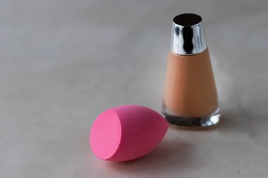 Pembe kozmetik sünger ve fondöten. Yumuşak odak.