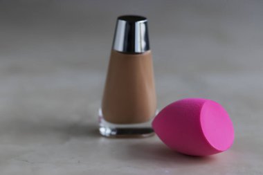 Pembe kozmetik sünger ve fondöten. Yumuşak odak.