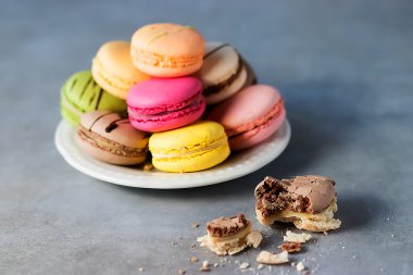 Gri arka planda beyaz bir tabakta çeşitli badem kurabiyeleri. Yumuşak odak.