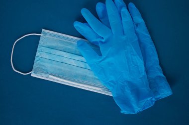 Mavi tıbbi maske ve mavi eldiven. Tıp ve sağlık kavramı. Üst görünüm.