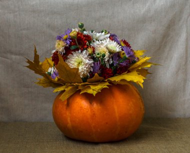 Bir buket çiçek ve sarı yapraklar ile kabak vazo