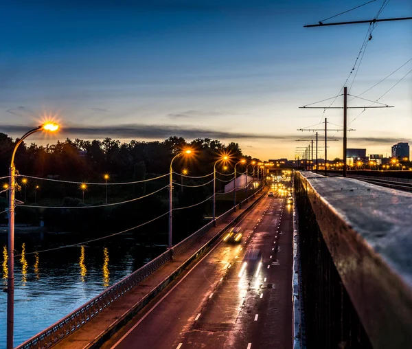 Köprünün üzerinde sadece güneş battıktan sonra otomobil seyahat — Stok fotoğraf