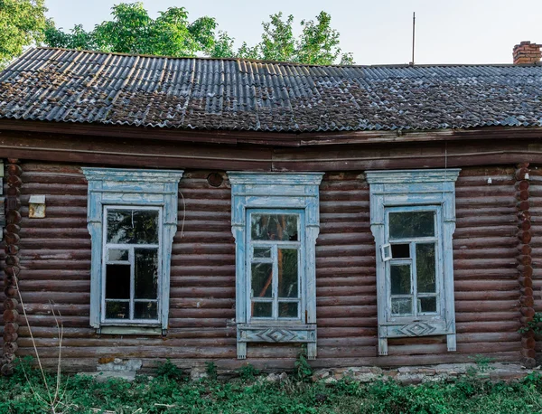 Facciata di una casa in legno abbandonata con finestre scolpite — Foto Stock